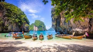 Traditional Thai Long-Tail Boats Anchored in Andaman Sea Caves