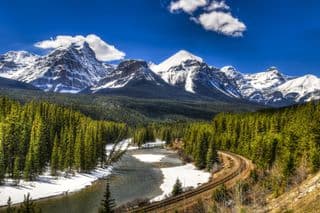 Banff National Park's Morant's Curve Railway amidst Snow-capped Peaks