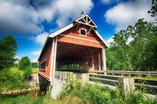 Traditional Red Covered Bridge amidst Lush Greenery