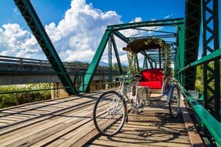 A Vibrant Tricycle Resting on an Old Wooden Bridge