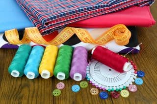 Colorful Thread Spools Arrayed Before Fabric