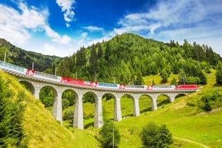 Red Train Crossing the Viaduct in Swiss Alps