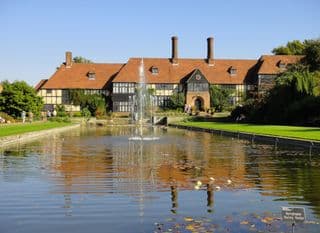 Reflection of Tudor Manor in Formal Water Garden at Wisley