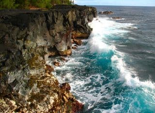 Ocean Waves Crashing against Lava Rock Cliffs