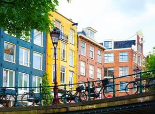 Bicycles Leaning Against Amsterdam Bridge Railings