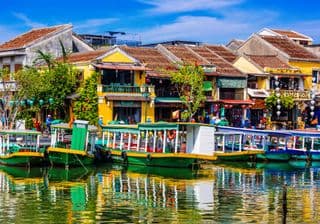 Traditional Boats Docked Alongside Colorful Buildings in Hoi An Ancient Town