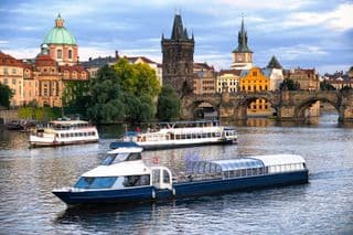 Boats Cruise Under the Charles Bridge in Prague