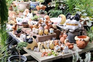 Whimsical Clay Animal Statues in Garden Setting