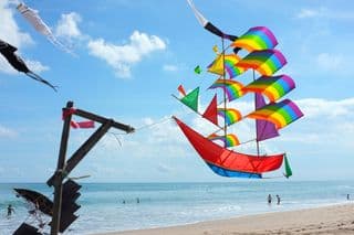 Vibrant Rainbow Kite Ship Soars Over Kuta Beach