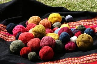 Vibrant Yarn Balls on Traditional Blanket