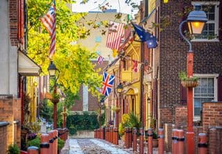 Flags flutter above historic brick buildings in Old City Philadelphia