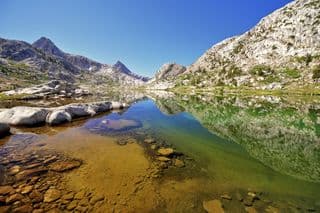 Reflection of Majestic Peaks in Clear Alpine Lake