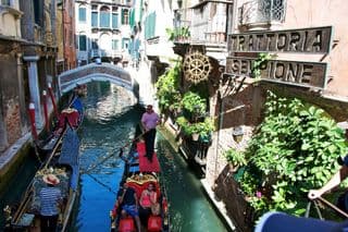 Gondoliers Paddling Through Venetian Canals