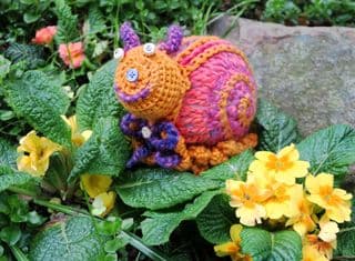 Handcrafted Crochet Snail Amongst Primroses
