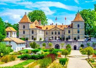 Prangins Castle and its Vibrant Gardens under Summer Skies